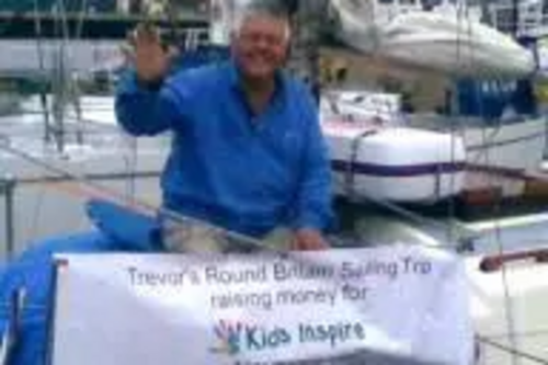 Trevor Nunn on his boat with the 'Kids Inspire' banner