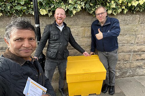 Left to right: Tahir, Cllr Colin and Cllr Tom standing outside newly installed grit bin.