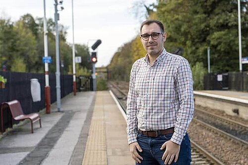 Tom Gordon MP at a train station.
