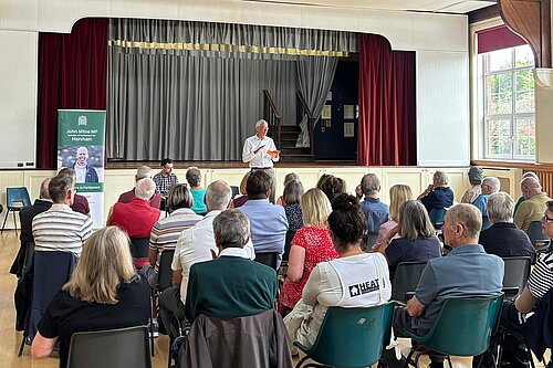 John speaking to residents on his summer tour