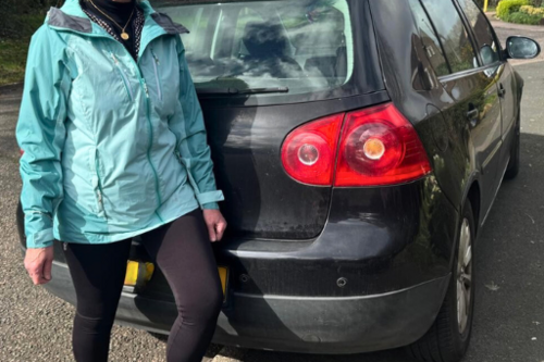 Cllr Marie Bradburn next to car parked partly on pavement