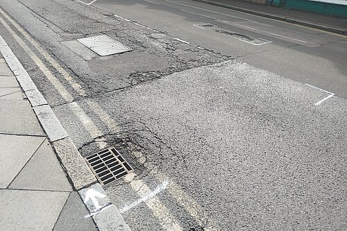 Potholes in road marked up for repair