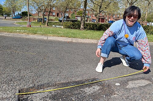 Emily Ho measures pothole