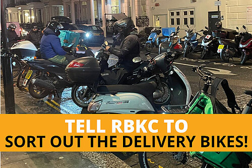 A line of delivery bikes parked on a road at night