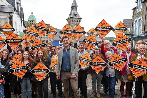 David Chadwick surrounded by supporters holding Lib Dem Diamonds