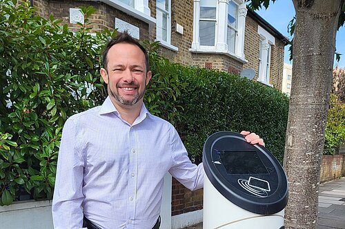 Cllr Gary Malcolm stood next to an EV charging station.
