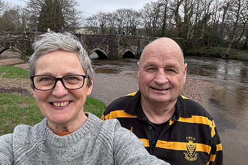 Cornwall councillors Sarah Preece and Jim Candy stand in front of the river Fowey, a bridge is in the background