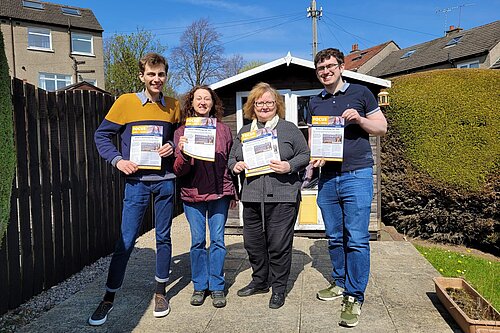 Group of Lib Dem volunteers holding up copies of a Focus leaflet.